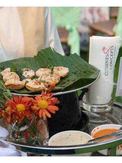 Spicy Kuzhi Paniyaram, a South Indian specialty, served on a banana leaf for an authentic touch. We take pride in showcasing the diverse and delicious cuisines from all across India.