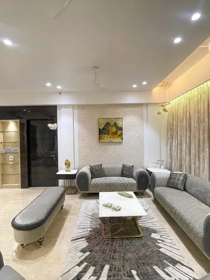 A different angle of the grey-themed living room, showing the comfortable sofa arrangement and the soft, ambient lighting. The space is designed to be a perfect retreat for unwinding after a long day.