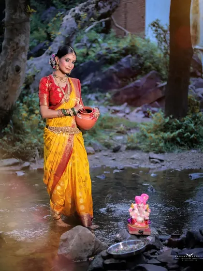 A full-length shot of the model standing in the stream, connecting the traditional attire with the elements of nature.
