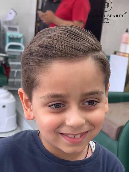 A smart and classic side-part haircut for this young boy. It's a timeless look that is perfect for any occasion.