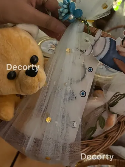 Another look at the beautifully assembled return gift baskets, featuring a plush teddy bear and custom aviator-themed tags.