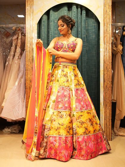 A client admiring the vibrant colors of a patchwork lehenga. This is the perfect outfit for a bridesmaid who wants to stand out and look festive.