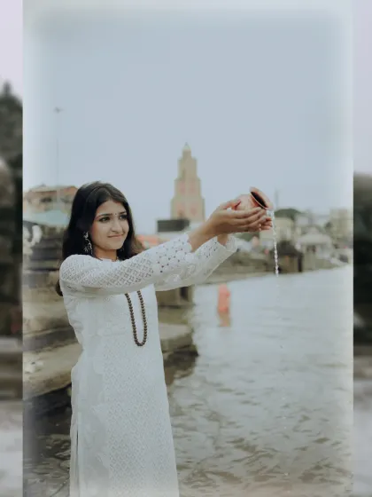 An offering to the river. This portrait captures a devotee in a white chikankari kurta making a water offering during the holy month of Shravan.
