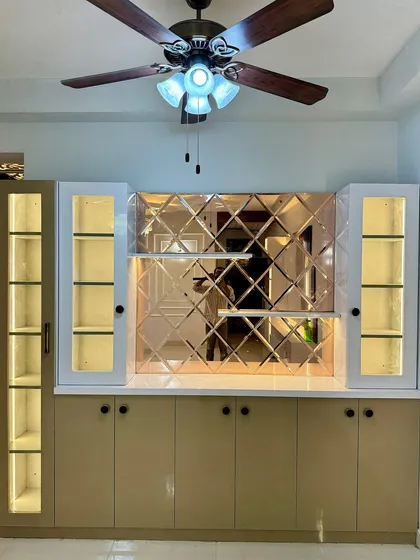 This crockery unit is both a storage solution and a centerpiece. I used a combination of closed cabinets, glass display shelves with internal lighting, and a designer mirror backsplash to create a truly premium look.