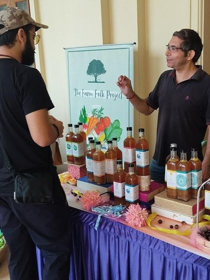 A producer from The Farm Folk Project explaining his products to a customer.