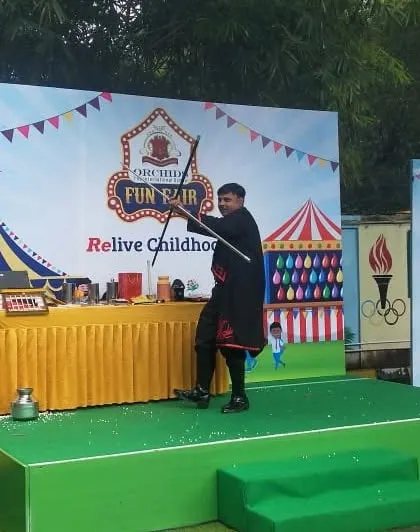 Using a magic wand and cane as part of an illusion during the Orchids Fun Fair. These classic props are essential to the magician experience.