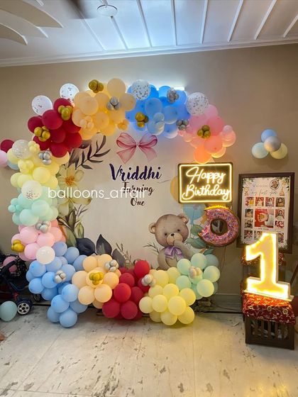 A full view of the colorful teddy bear first birthday, including a framed photo collage of the baby's first year.