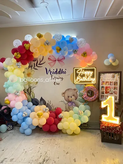A full view of the colorful teddy bear first birthday, including a framed photo collage of the baby's first year.