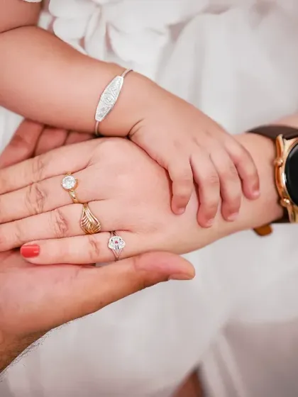 Three hands, one family. This close-up shot of the parents' and baby's hands is a powerful symbol of their bond.