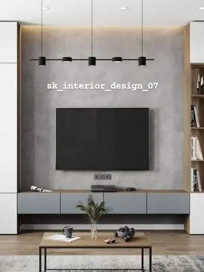 This TV unit is set against a concrete-finish wall, flanked by white storage cabinets and a wooden display shelf. The track lighting adds an industrial-chic vibe.