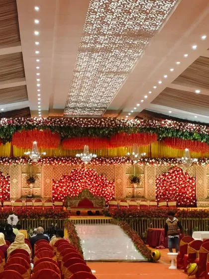 We transform grand venues into breathtaking scenes for your special day. This wedding reception setup features a magnificent floral stage, dramatic lighting, and seating for hundreds of guests, all meticulously planned to create a royal and elegant atmosphere.