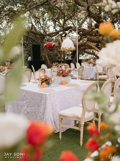 A peek at the dining setup through a curtain of flowers, creating a soft-focus, dreamy view of the elegant tables.