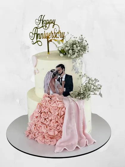 I love making cakes that tell a story. This two-tier anniversary cake features an edible image of the couple, framed by a cascade of hand-piped pink fondant ruffles.