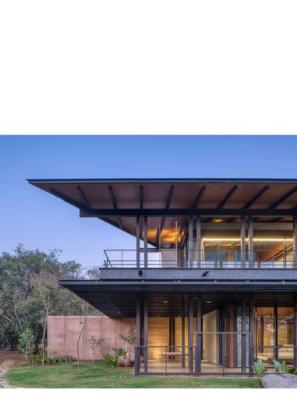 The house viewed from the garden, showing the interplay of the solid rammed earth walls and the light, transparent glass facades.