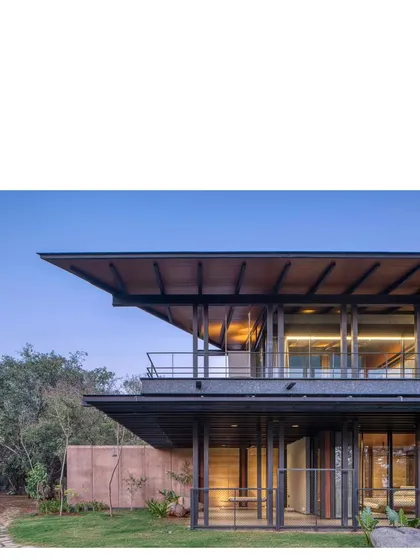 The house viewed from the garden, showing the interplay of the solid rammed earth walls and the light, transparent glass facades.