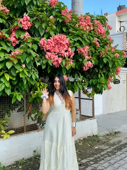 A simple and sweet look in a tiered white maxi dress. The beautiful pink flowers in the background make this a perfect spring or summer shot.