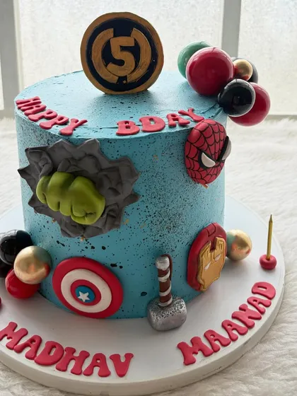A superhero party isn't complete without a superhero cake! This one was for a huge Marvel fan, featuring all the Avengers' symbols like Hulk's fist, Captain America's shield, and Thor's hammer, all handcrafted by me.