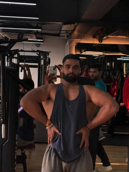Hard work pays off. A member showing off his impressive back and shoulder development after a tough workout.