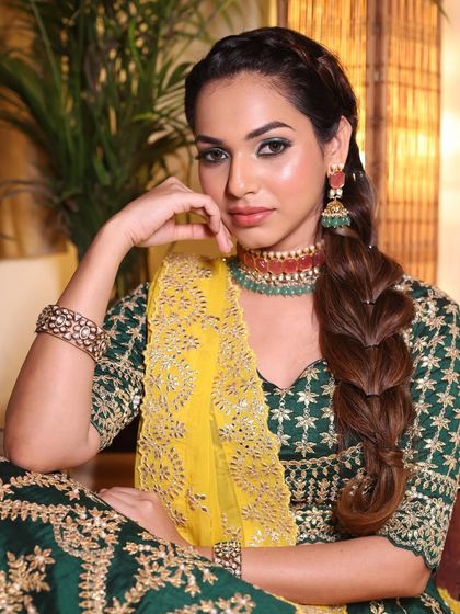 A powerful and confident pose. The unique braided hairstyle and the bold green eye makeup create a look that is both strong and beautiful.