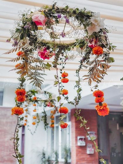 Minimalistic floral chandeliers created for a Mehndi ceremony. We used simple hoops adorned with greenery, marigolds, and other delicate flowers to add a touch of beauty to the ceiling space.