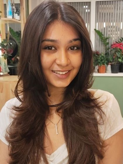 This photo showcases the texture and movement created by the layers in her medium-length hair.