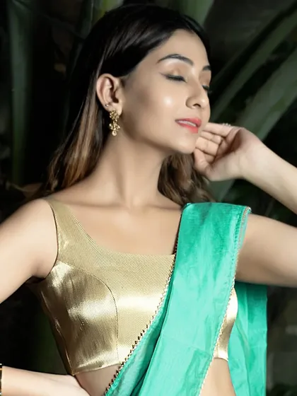 Another angle of the golden brocade sleeveless blouse, paired here with a sea-green saree. The combination of gold and green is timeless, and the simple cut of the blouse lets the fabric shine.