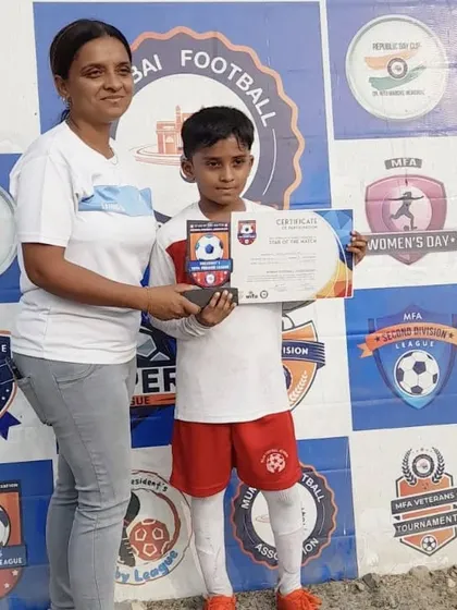 **Individual Achievements:** A young player receiving his Star of the Match certificate and trophy from the Mumbai Football Association.