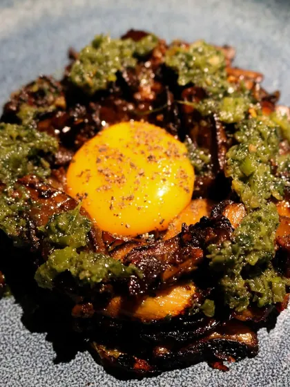 A creative dish from Grumps, Goa: charred mushrooms topped with a bright egg yolk and a zesty green sauce.