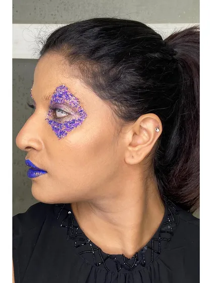 A profile view of the geometric glitter makeup. This shows how the look is constructed to be striking from all angles, a key consideration for fashion photography.