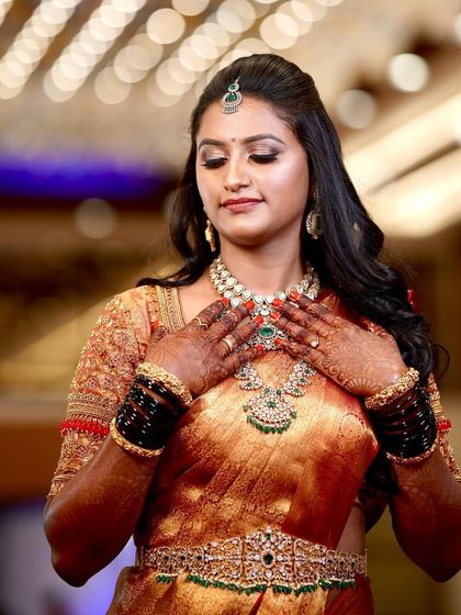 Supriya adjusting her beautiful jewellery. The makeup was designed to be long-lasting and picture-perfect from every angle throughout her reception event.