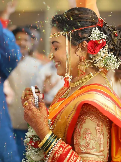 A beautiful action shot as flowers are showered on the bride. Her makeup is set to perfection, ensuring it stays flawless even during the most lively moments.