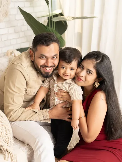 A cozy and happy family portrait. This close-up shot captures the tight-knit bond of this family of three in a relaxed studio setting.