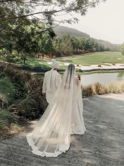 A portrait from behind, showcasing the magnificent veil and the stunning landscape. This image tells a story of a journey beginning, with the couple walking towards a beautiful, open future.