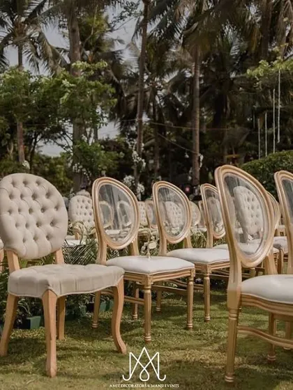 A mix of classic tufted chairs and modern transparent chairs adds visual interest to the guest seating, all unified by the elegant white and gold color scheme.