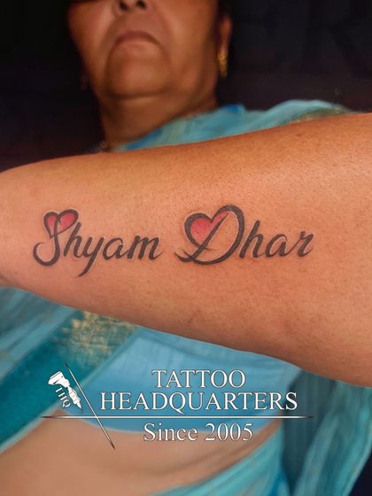 The name "Shyam Dhar" tattooed with two red hearts, a loving tribute.
