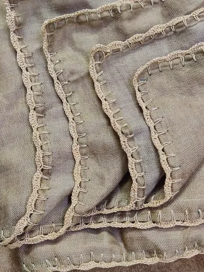 For a unique look, we added a simple yet elegant crochet lace edge to this beautiful grey shawl. This kind of custom work can completely transform a piece.