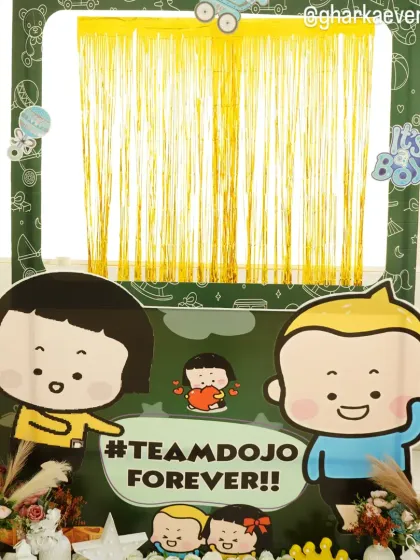 A fun and unique '#TeamDojo Forever' themed photo booth with cute character cutouts and a gold shimmer curtain.