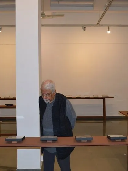 An art patron observing the reverse paintings on display at 'Quieter than Silence'.