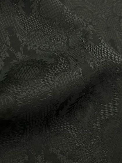 A close-up of a black-on-black patterned fabric, perfect for adding subtle elegance to an evening jacket or sherwani.
