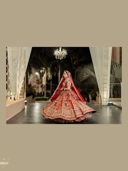 A twirling shot of the bride in her magnificent red lehenga, capturing the movement and beauty of her wedding attire.
