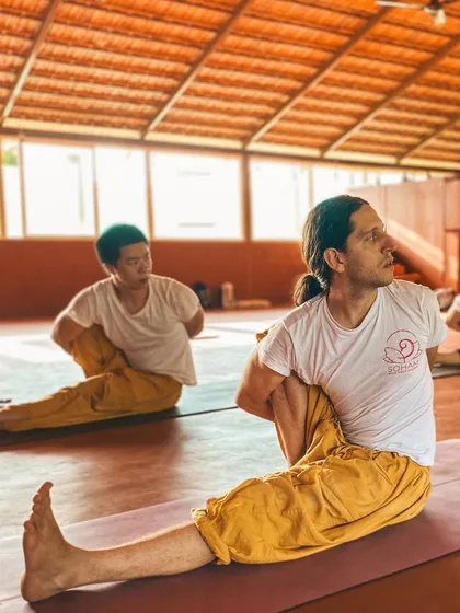 This is a duplicate of image 90. A student demonstrates a deep seated twist, showcasing the flexibility and strength gained through the program.
