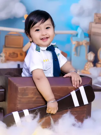 A smiling little pilot, ready for takeoff. We capture a variety of poses and expressions to tell a complete story.