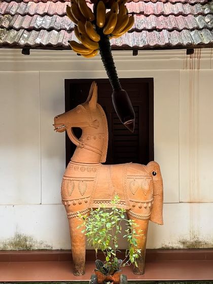 A terracotta horse sculpture in the courtyard of a heritage property, an element of local art and culture that adds soul to the architectural space.