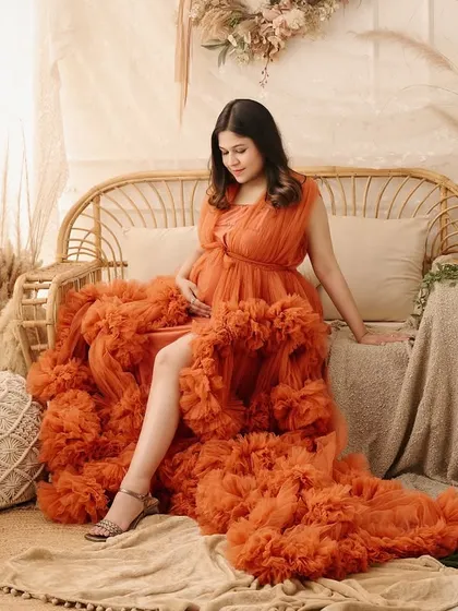 A full-length view of a stunning orange ruffled gown within our boho set. This shot showcases how we combine high-fashion gowns with our themed decor for a unique look.