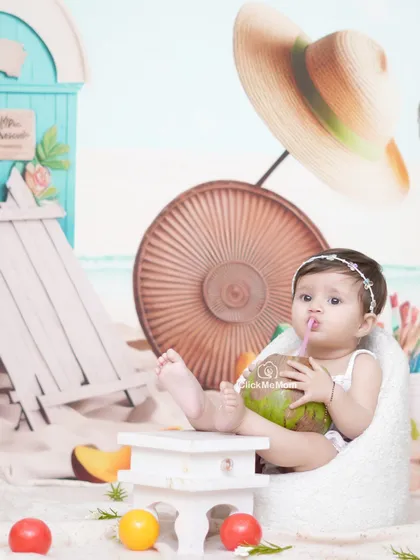 Enjoying a refreshing drink of coconut water. Our beach setup includes real sand and fun props to create an authentic seaside vibe.