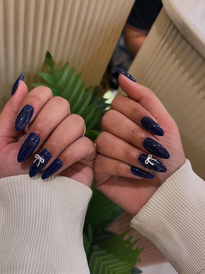 This elegant navy blue manicure is made even more special with the addition of a cute 3D bow.