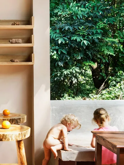 Children play by a large window that frames the dense Goan foliage, a scene that captures the essence of Unallome. The design seamlessly integrates the indoors with the outdoors, creating a space that feels open, natural, and full of life.