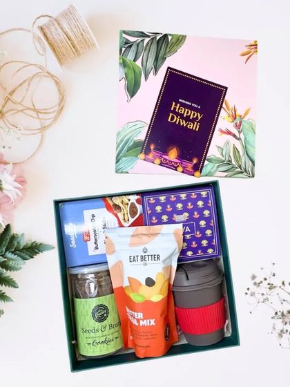 This hamper is perfect for the health-conscious foodie. It includes a reusable coffee mug, a pack of trail mix, seeds and berries cookies, butterscotch dip sticks, and assorted chocolates.