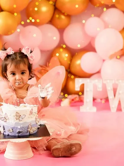 Two looks so sweet! This little fairy is having the best time at her second birthday cake smash, with frosting on her face and a big smile. It's never too late for a fun smash session.