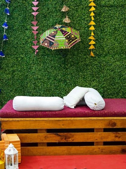 A cozy seating area with a traditional "diwan" setup, decorated with colorful umbrellas and lanterns for an authentic Punjabi feel.